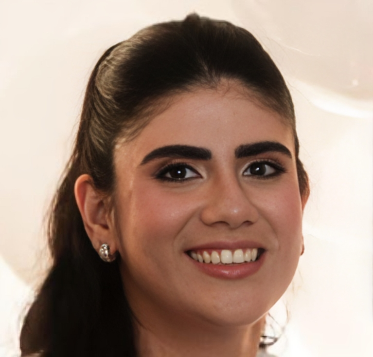 A woman with long dark hair pulled back, smiling, wearing stud earrings and natural makeup, stands against a softly blurred light background, embodying the confidence and professionalism often associated with the Clarvida MSEP partnership.